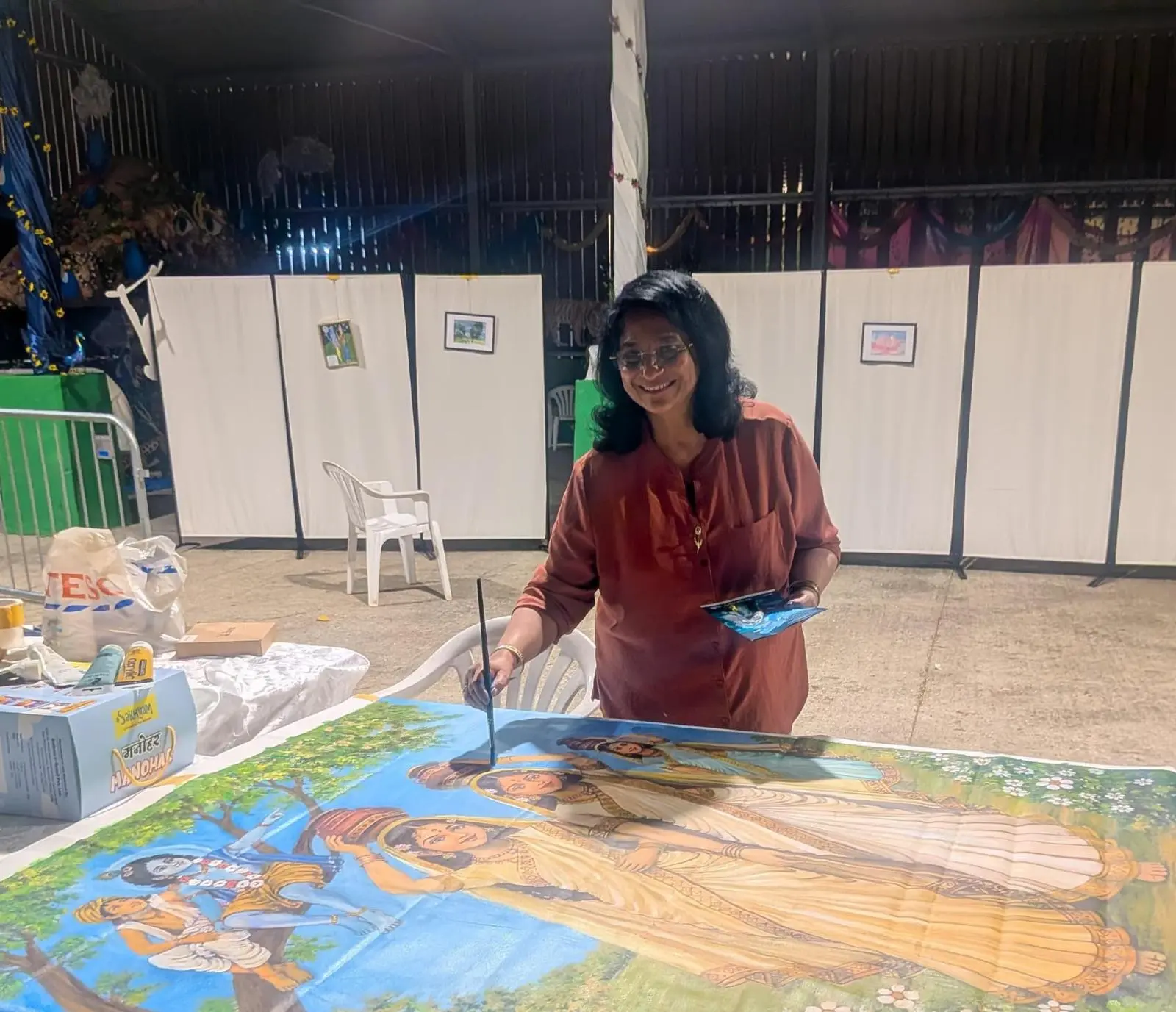 Millie Basu-Roy painting a large colourful work during a live art event
